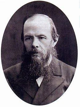 A black-and-white oval-framed portrait photograph of a bearded middle-aged man in a dark coat, consistent with 19th-century photographic style. Depicts: Fyodor Pavlovich Karamazov.