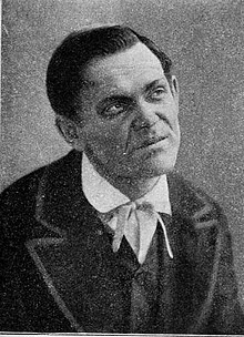 Vintage theatrical portrait: gaunt, hollow-cheeked actor with slicked hair and intense gaze — the Smerdyakov iconography of the 1910 MAT premiere. Depicts: Pavel (Pavel Fyodorovich) Smerdyakov.